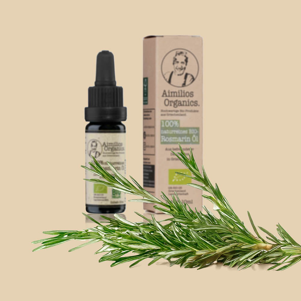 Aimilios Organics Bio Rosmarin Öl auf braunem Hintergrund mit Rosmarin Pflanzen im Vordergrund