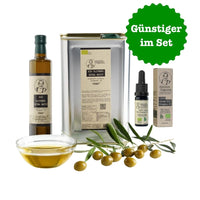 Aimilios Organics 3L Kanister und 500ml Flasche griechisches sortenreines Bio Olivenöl und 10ml Flasche ätherisches bio Oregano Öl auf weissem Hintergrund mit Oliven und Olivenöl als Deko im Vordergrund