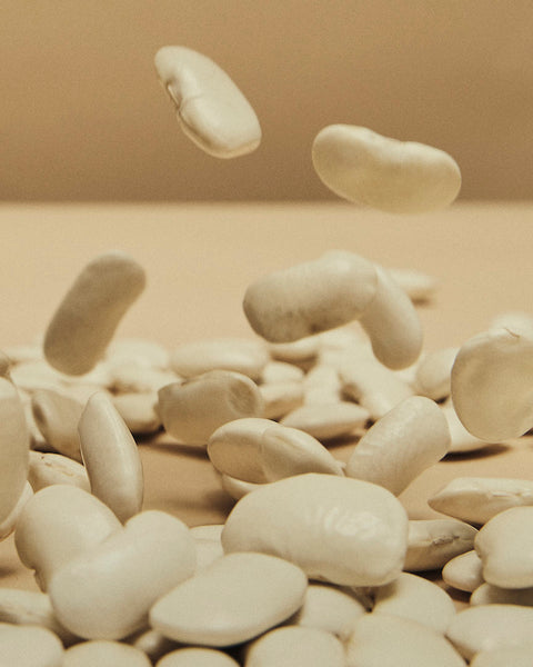 Aimilios Organics Weiße Bio-Riesenbohnen Nahaufnahme, Bohnen die vom oberen Bild auf den Boden fallen 